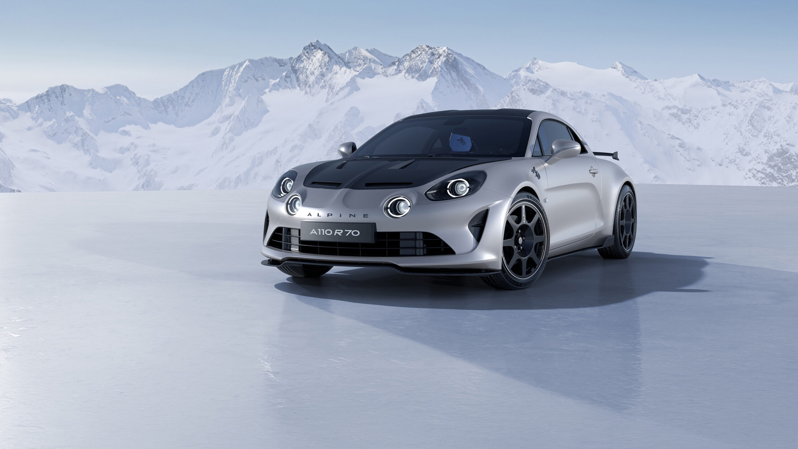 Sportwagen Alpine A 110 R 70 in Silber mit schwarzer Carbonmotorhaube vor weißen Berggipfeln