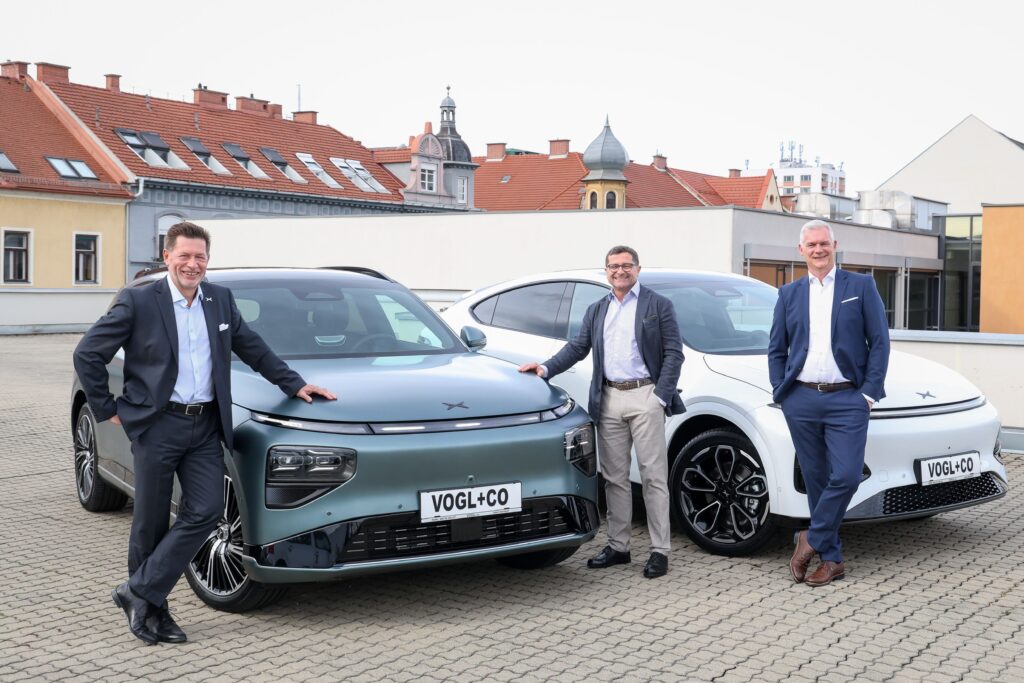 Mag. Ing. Georg R. Staudinger (Country Manager von XPENG Österreich), Mag. Gerald Auer (Geschäftsführer Vogl+Co) und René Pardon (Geschäftsführer Vogl+Co) präsentieren den XPENG G9 und G6 auf dem Dach bei VOGL+Co.